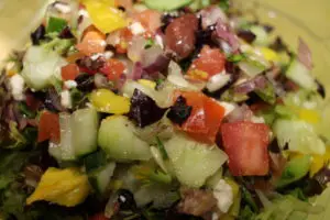 A close up of the salad with tomatoes and cucumbers